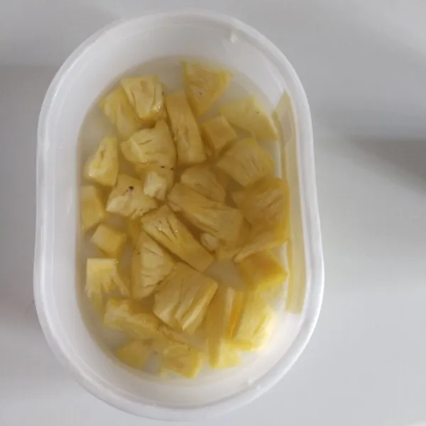 Potong nanas kecil-kecil dan rendam dalam air putih yang sudah dicampur garam selama 5 menit.