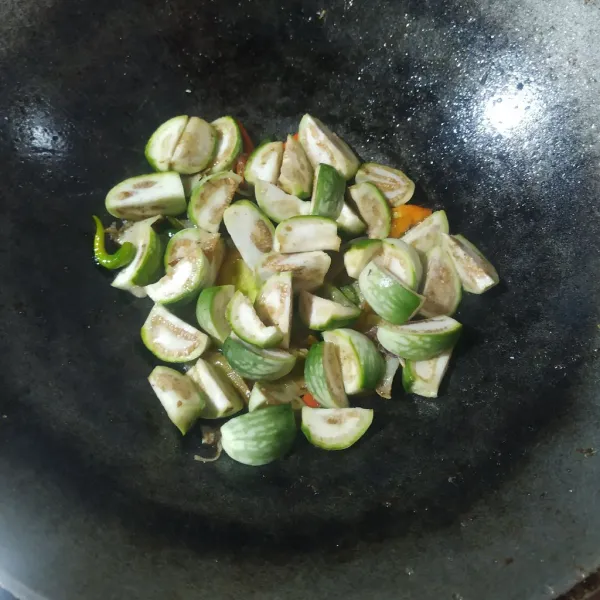 Masukkan terong, beri air, bumbui garam, gula pasir dan kaldu bubuk, aduk rata dan koreksi rasanya.
