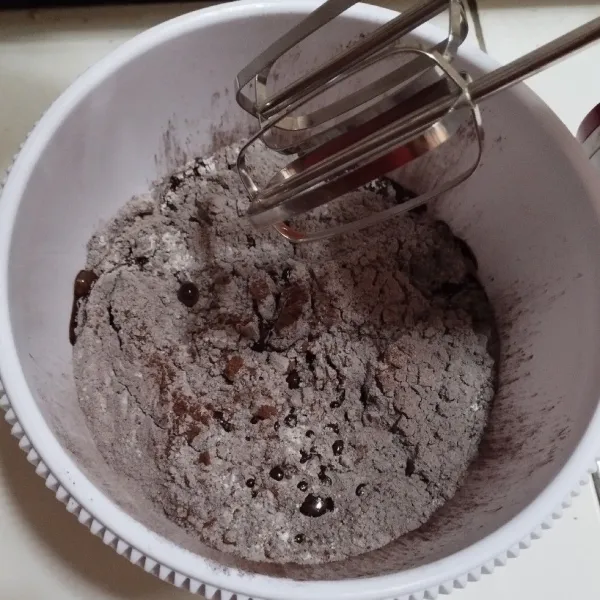 Dalam wadah mixer, masukkan telung terigu, coklat bubuk, gula pasir, vanili, dan garam yang sudah diayak terlebih dahulu. Tambahkan telur dan susu cair, mixer asal rata dengan kecepatan rendah selama satu menit