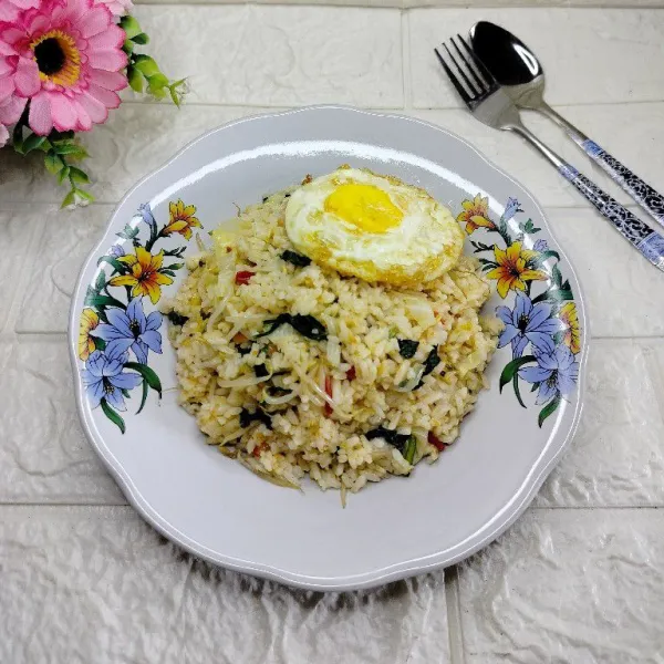 Tuang nasi goreng ke dalam piring, sajikan dengan telur ceplok.