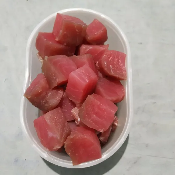 Cuci bersih ikan tuna, lalu potong berbentuk dadu