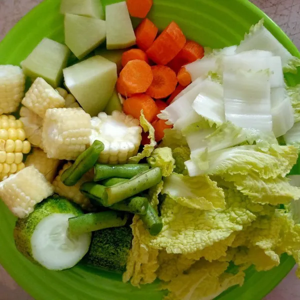 Potong semua sayuran, jagung, labu siam, wortel, buncis, timun dan sawi.