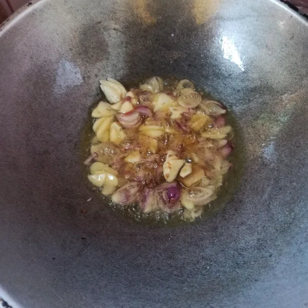 Tumis bawang merah, bawang putih dan lengkuas sampai harum dan matang.