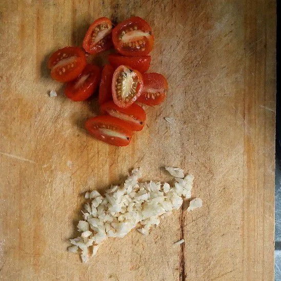 Cincang bawang putih dan potong tomat