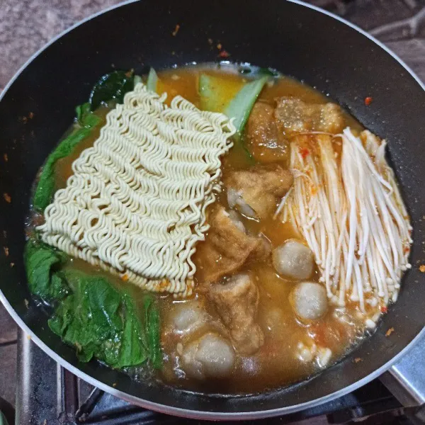 Masukkan sawi pakcoy, jamur enoki, cilok, mie Kering, koreksi rasa, masak sampai matang semua.