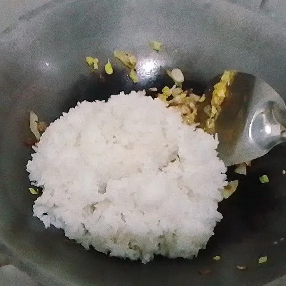 Masukkan nasi dan campurkan dengan bumbu dan bahan lainnya beberapa saat.