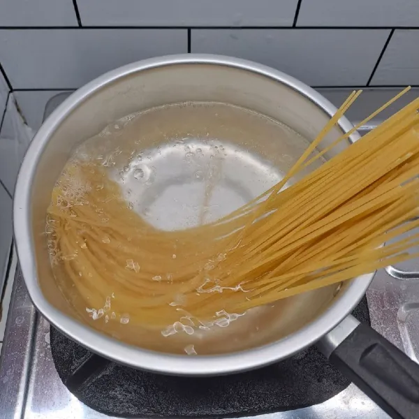 Rebus air sampai mendidih. Masukkan spaghetti, beri garam dan minyak goreng. Masak sampai spaghetti matang. Angkat dan tiriskan lalu sisihkan.