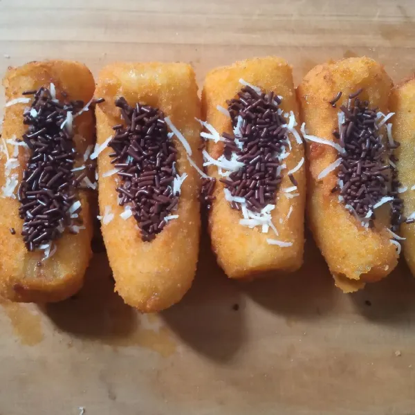 Setelah uap panasnya berkurang, isi liang pisang dengan keju parut dan meses, sajikan.