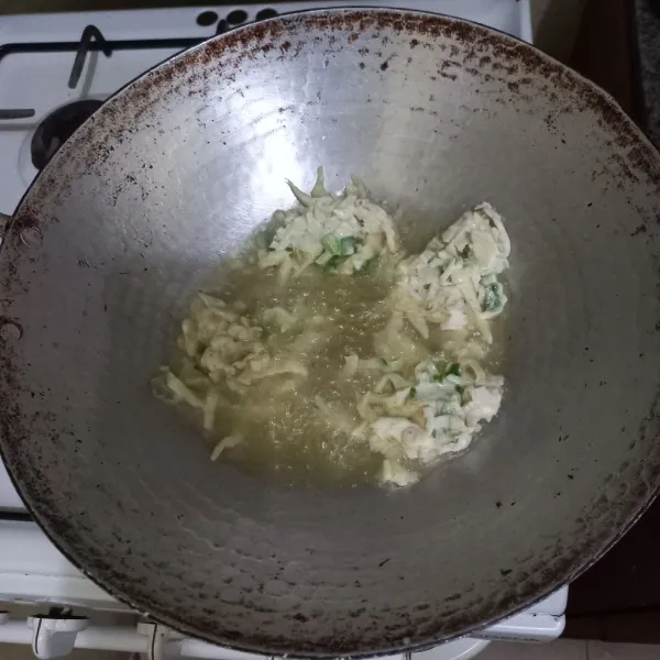 Panaskan minyak goreng pada wajan, goreng adonan hingga matang kecokelatan.