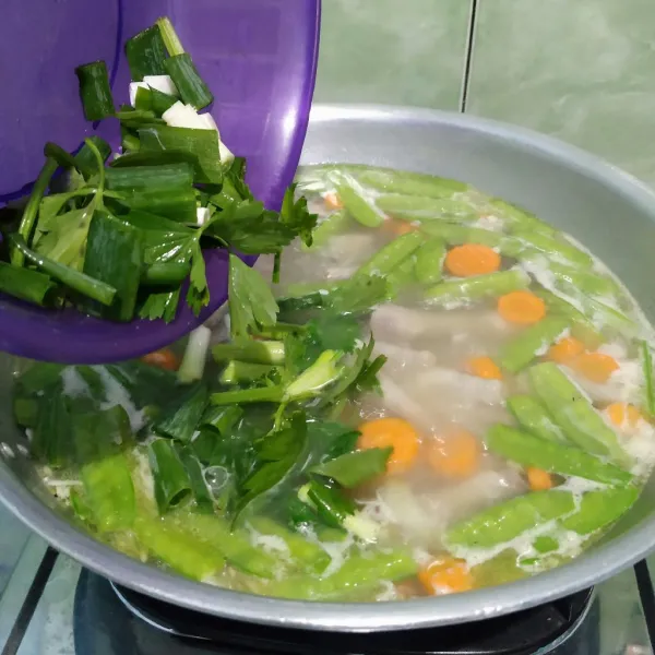 Masukkan daun bawang dan seledri, lalu aduk rata.