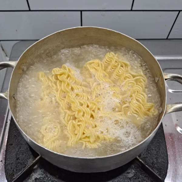 Rebus air secukupnya sampai mendidih. Masukkan mie, masak sampai empuk. Lalu angkat dan tiriskan, beri 1 sdm minyak goreng agar mie tidak lengket lalu sisihkan.