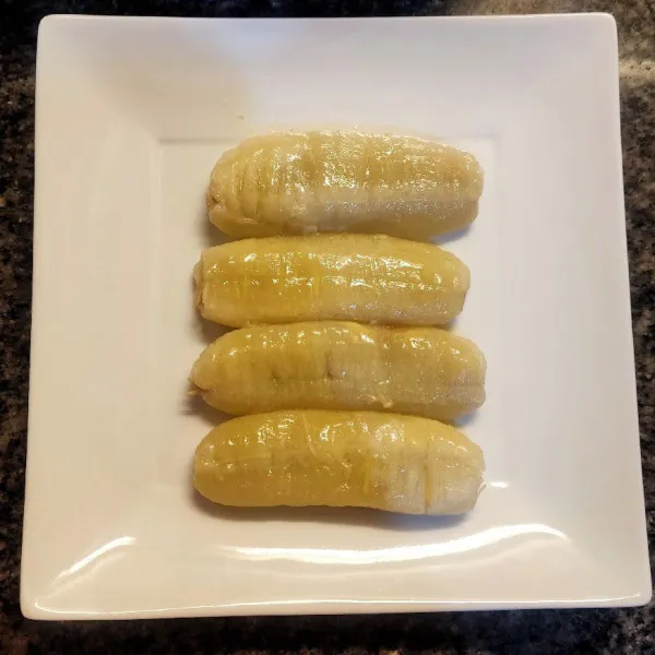 Olesi pisang dengan margarin selagi masih panas sambil pipihkan pisang dengan menggunakan garpu.