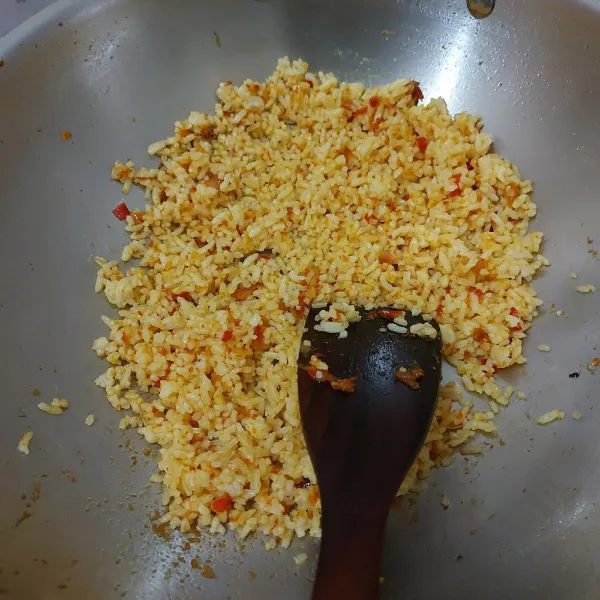Aduk-aduk nasi hingga tercampur merata dengan bumbu. Kemudian bubuhi dengan garam dan lada. Tes rasa dan sisihkan.