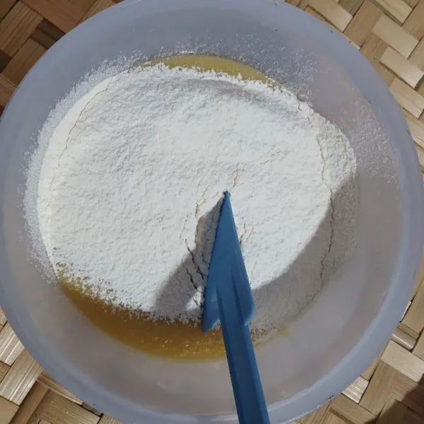 Tuang ke dalam wadah, tambahkan tepung yang sudah diayak, aduk rata.