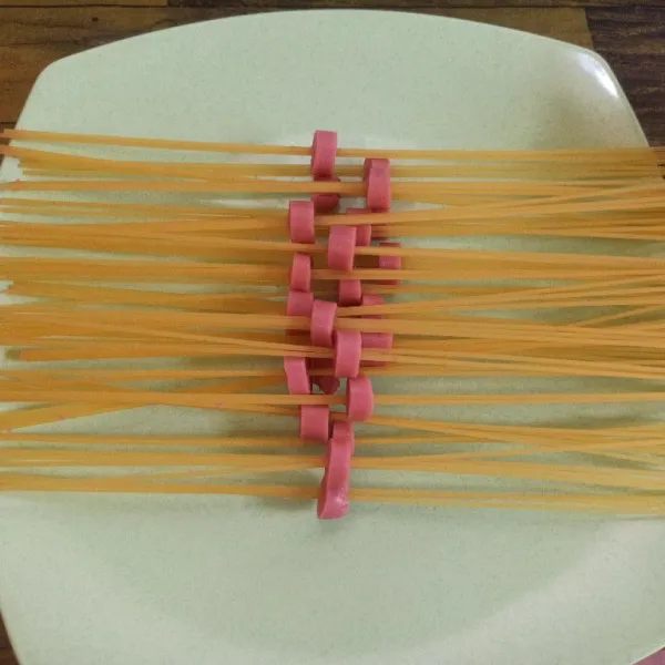 Ambil 3-4 buah spaghetti kemudian tusuk dengan sosis, lakukan hingga selesai.