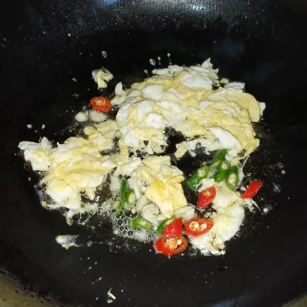 Masukkan bawang putih cincang dan irisan cabai rawit, lalu tumis sampai harum.