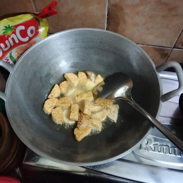 Panaskan minyak, kemudian goreng tempe hingga kuning kecoklatan, lalu angkat dan tiriskan.