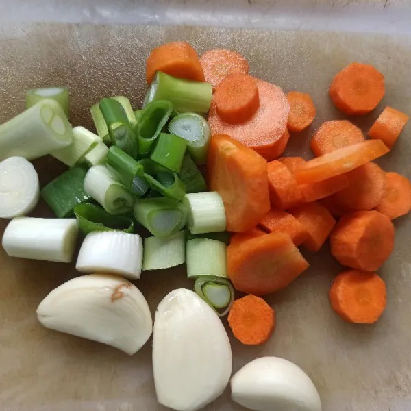 Kupas, lalu potong-potong wortel dan daun bawang agar lebih mudah menghaluskannya
