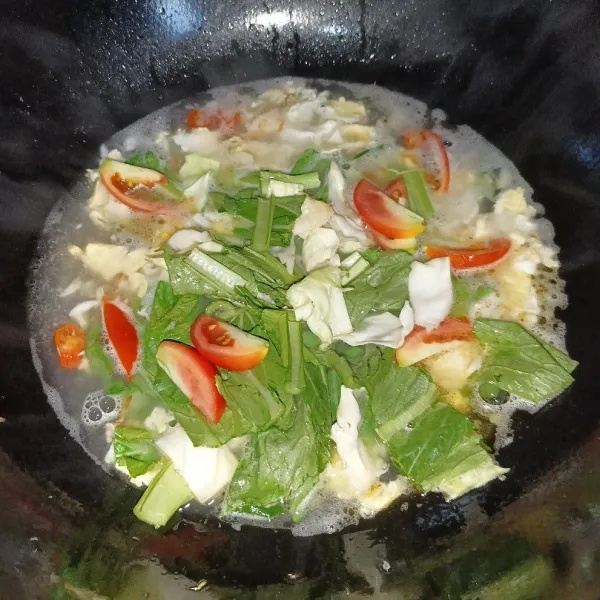 Masukkan sawi, kol dan tomat, aduk rata.