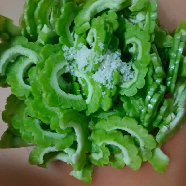 Sayur pare yang sudah diiris beri garam.