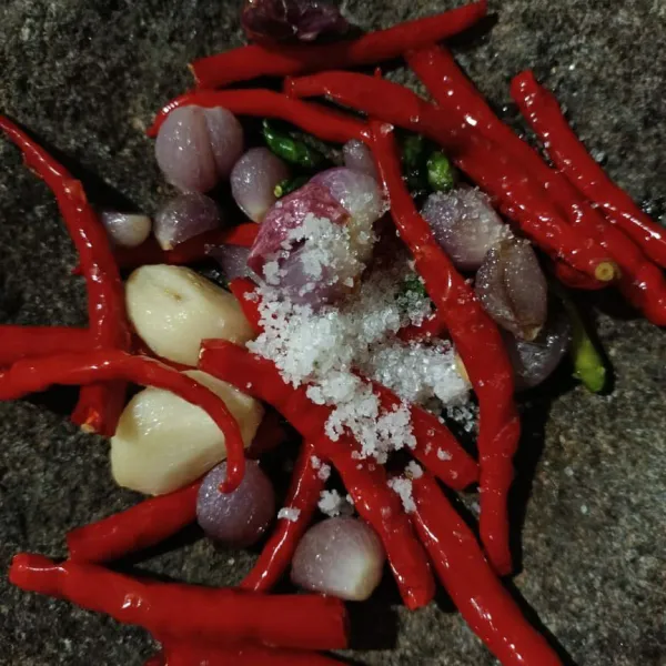 Dalam cobek masukkan cabe merah, cabe rawit, bawang merah, bawang putih yang sudah digoreng. Tambahkan garam dan gula pasir.