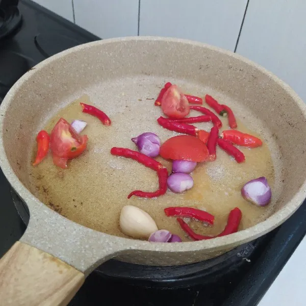 Untuk membuat sambalnya, panaskan minyak dalam wajan. Goreng bahan sambal, tomat, cabai, bawang putih, dan bawang merah