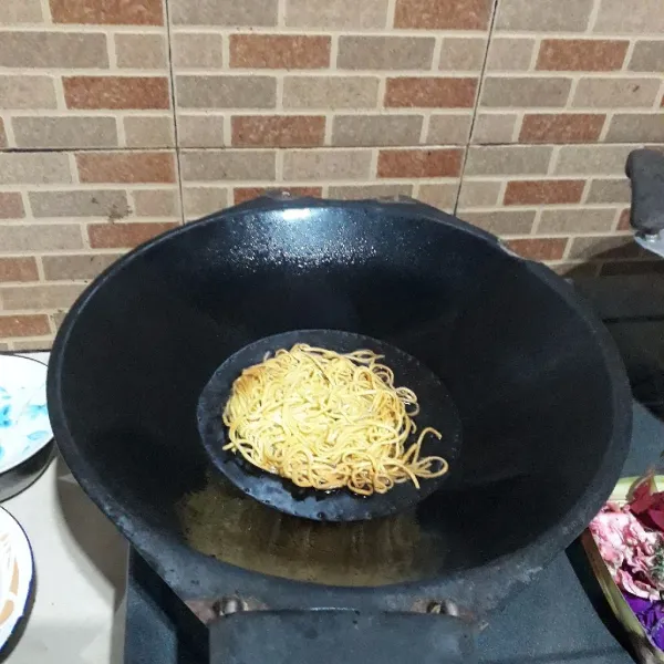 Bentuk bulat pipih mie, goreng dalam minyak panas hingga renyah kecoklatan, tiriskan.