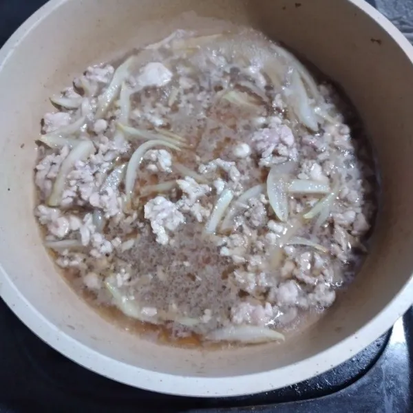 Masukkan ayam giling dan bombay, aduk-aduk.