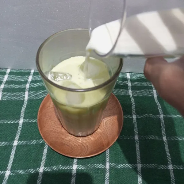 Tuangkan susu full cream hingga gelas hampir penuh.