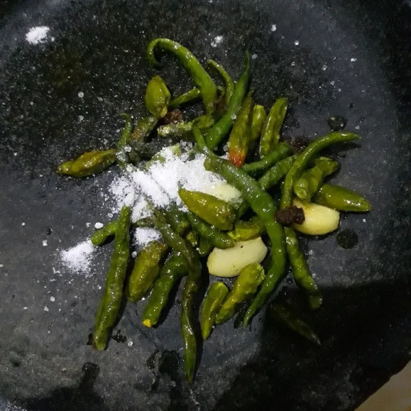 Haluskan bawang putih, cabe rawit hijau dan cabe hijau keriting dengan garam, penyedap rasa dan gula pasir lalu koreksi rasa.