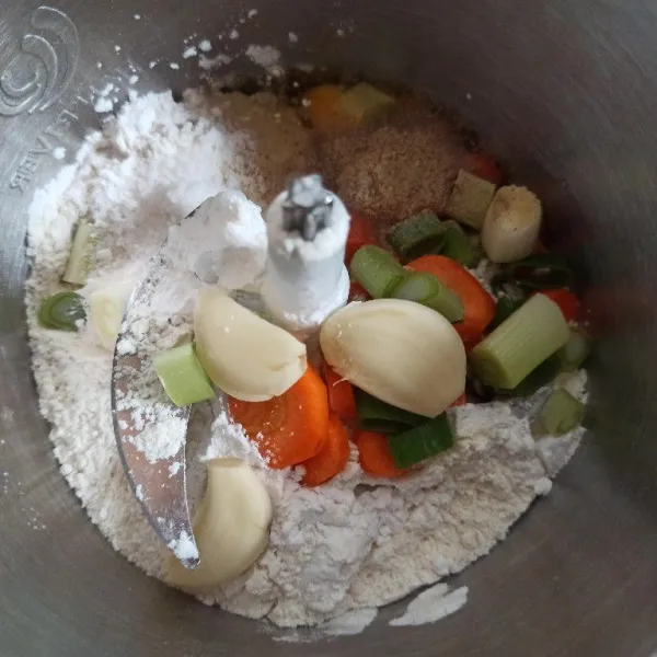 Masukkan tahu, tepung terigu, tepung tapioka, bawang putih, daun bawang, wortel, telur, garam, lada bubuk, dan kaldu bubuk ke dalam chopper