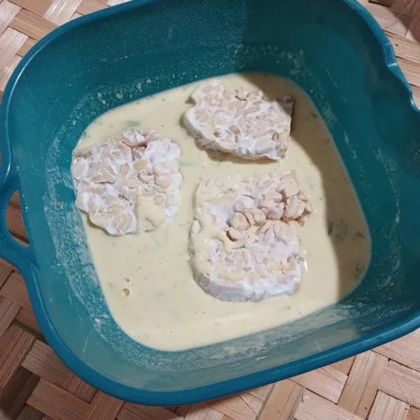 Celupkan tempe ke dalam adonan tepung.