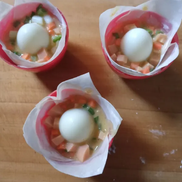 Isi dengan telur sebanyak 1.5 sdm. Letakkan telur puyuh ditengan. Tekan masuk.