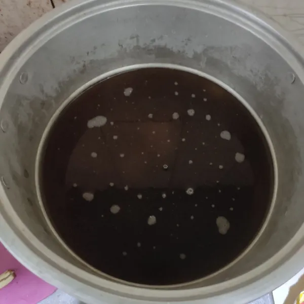 Di panci ukuran besar masukkan air, gula aren, gula merah, gula pasir dan asam jawa matang. Sambil diaduk masak hingga semua gula larut.