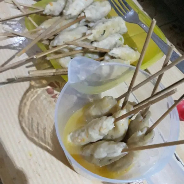 Kocok telur dengan garam dan kaldu ayam bubuk. Celupkan sempol ayam ke dalam kocokan telur.