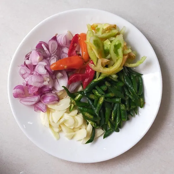 Siapkan semua bahan bumbu iris, bawang merah, bawang putih, cabai rawit merah, cabai hijau, dan tomat.