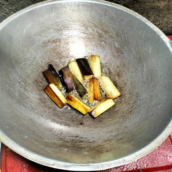 Panaskan minyak lalu goreng terong hingga layu.