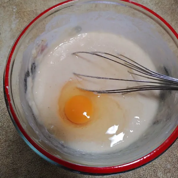 Masukkan air, aduk-aduk sampai adonan licin, kemudian masukkan telur dan kocok sampai tercampur rata.