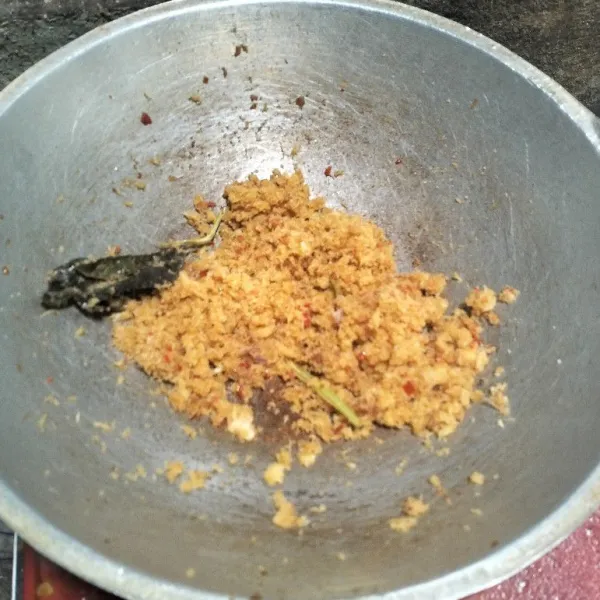 Tambahkan bumbu penyedap, ketumbar bubuk, dan merica bubuk. Masak hingga kering dan minyak berkurang.