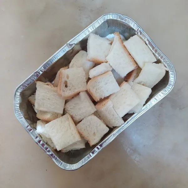 Potong-potong roti tawar lalu tata di loyang.