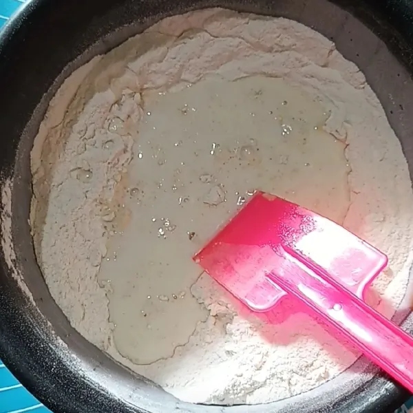 Campurkan tepung terigu, ragi, gula pasir, dan kuning telur, lalu aduk rata. Tambahkan susu cair dingin dan uleni hingga kalis