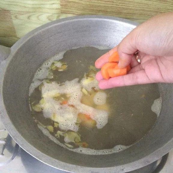 Masukkan kentang dan wortel lalu masak hingga empuk.