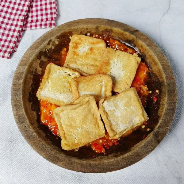 Penyet tahu goreng di atas sambal dan siap disajikan.