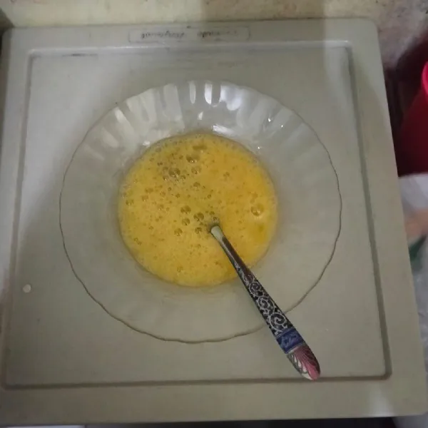 Kocok satu butir telur, lalu beri garam dan kaldu jamur aduk hingga rata dan kocok hingga berbusa.