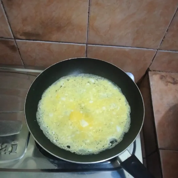 Panaskan teflon, beri sedikit minyak goreng, lalu masukkan telur.