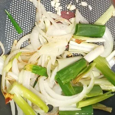 Tumis bawang bombay, bawang putih, dan daun bawang hingga harum.