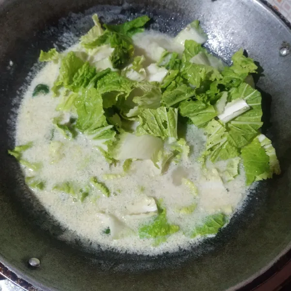 Masukkan sawi, aduk rata. Masak sampai sawi matang, jangan lupa koreksi rasanya.
