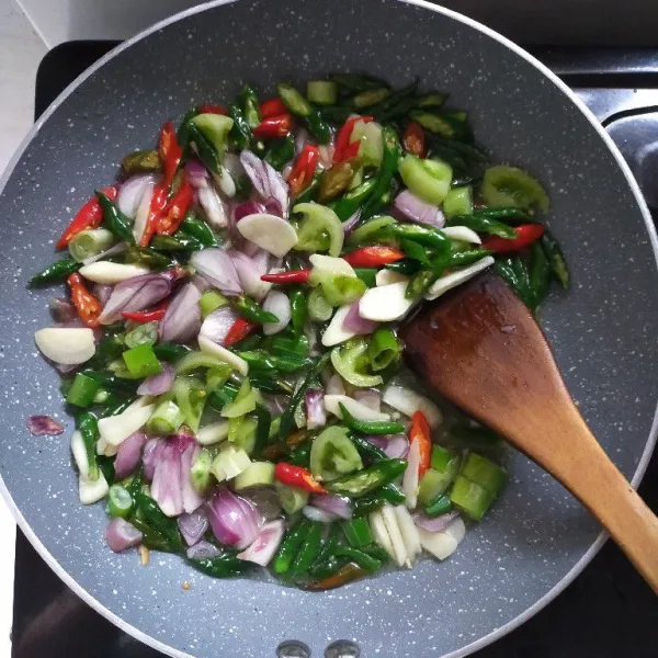 Tumis bumbu iris dan daun bawang hingga harum dan layu.