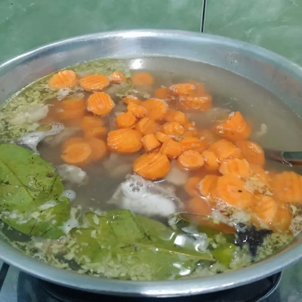 Masukkan wortel dan balungan sapi, masak hingga wortel empuk.