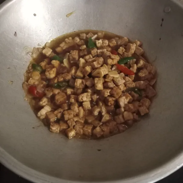 Masukan air, tempe dan kecap lalu aduk.